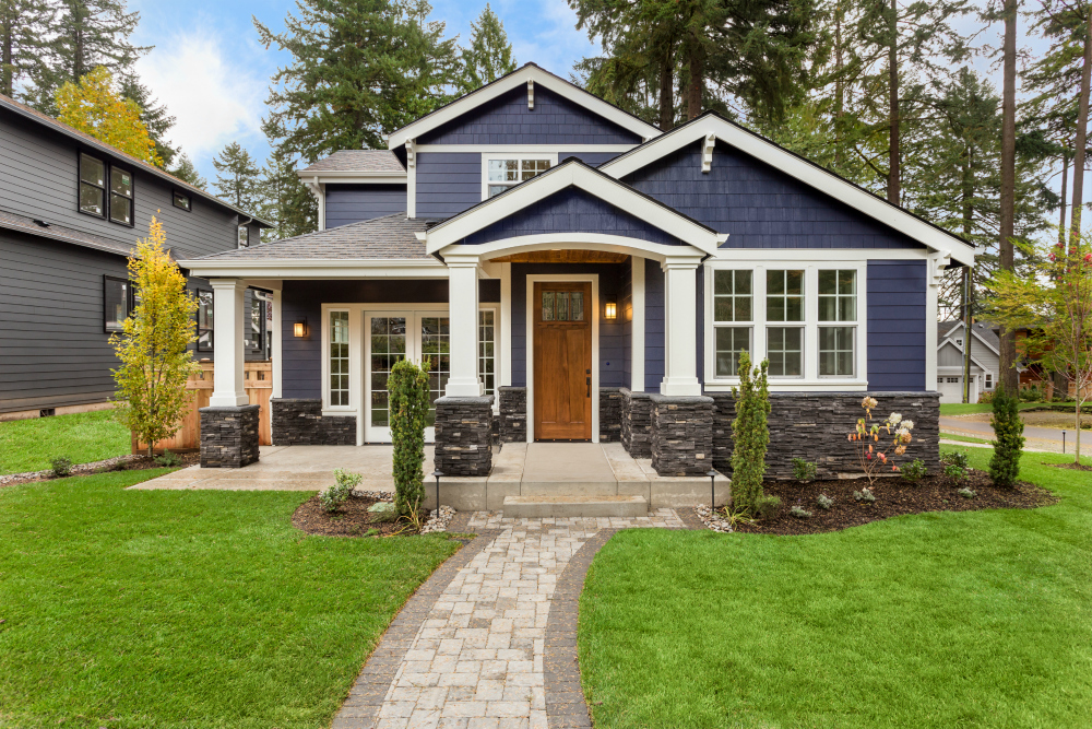 Beautiful blue house with white trim and a green lawn.