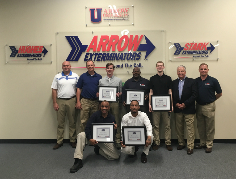 Group of Arrow Exterminators team members posing at training academy. 