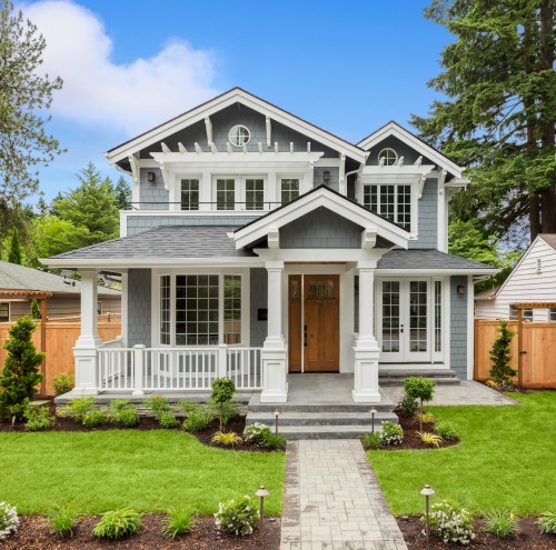 A two story home with a grass front yard.